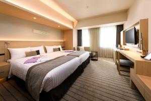 静冈HOTEL OLE INN的一间酒店客房,配有一张大床和一台平面电视