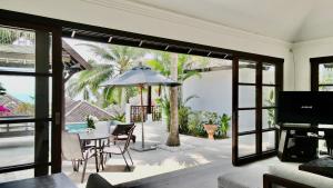 苏梅岛3 Bedroom Seaview Villa Halo on Beachfront Resort的客厅配有桌子和雨伞