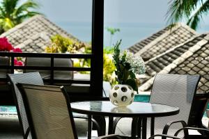 苏梅岛3 Bedroom Seaview Villa Halo on Beachfront Resort的天井上花瓶的桌子