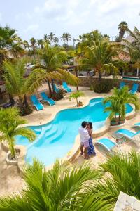 克拉伦代克Aqua Viva Suites的两名儿童站在度假村游泳池前