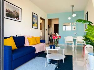 振林山SeaView 2-bedroom Fully Furnished Apartment Forest City #freeWIFI的客厅配有蓝色的沙发和桌子