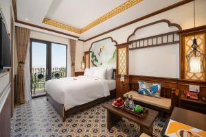 会安Hoi An Babylon Riverside Hotel & Spa的酒店客房设有床和窗户。