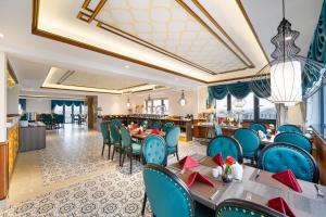 会安Hoi An Babylon Riverside Hotel & Spa的一间配备有蓝色椅子和桌子的用餐室