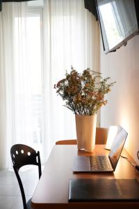 里米尼日落酒店的一张桌子上放着笔记本电脑和盆栽植物