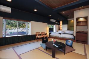 鸭川市Uminoniwa的卧室配有一张床和一张桌子及椅子