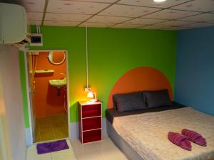 高兰猫简易别墅旅馆的一间卧室设有一张床和绿色的墙壁