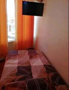 普诺Hospedaje Sumita Wasi的卧室配有一张床铺,墙上配有电视