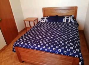 普诺Hospedaje Sumita Wasi的一间卧室配有一张带蓝色和白色棉被的床