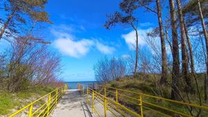 萨比诺瓦Domki Letniskowe Sarbilove的一条通往海滩的黄色围栏