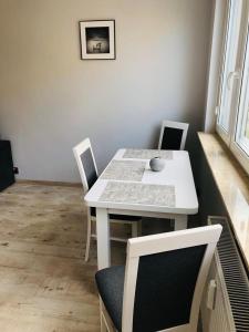 弗瓦迪斯瓦沃沃Apartament Morski Relaks的用餐室内的白色桌椅
