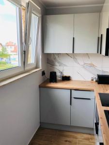 弗瓦迪斯瓦沃沃Apartament Morski Relaks的厨房配有白色橱柜和木制台面