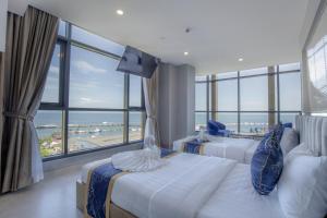 西哈努克Seascape Palace Hotel的酒店客房设有两张床和大窗户。