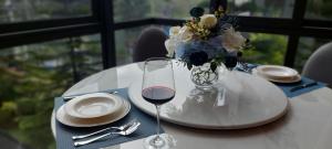 Ban Huai Sok NoiExeclusive Suite 209 by Forest Khaoyai的一张桌子,上面放着一杯葡萄酒和花瓶