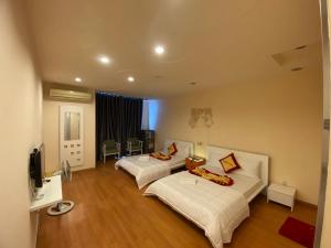 胡志明市Phú Gia Hotel的酒店客房设有两张床和电视。