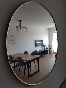 波兹南Apartament Wyłom 8的一间设有一张桌子和椅子的镜子用餐室