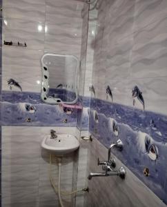 瓦拉纳西阿祖尔旅馆的浴室设有水槽,墙上设有海豚淋浴。