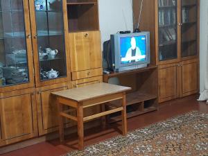 切尔尼戈夫Эконом вариант - спальный район的客房设有桌子、电视和木制橱柜。