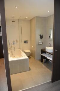 圣阿芒莱索帕斯诺酒店的带浴缸、卫生间和盥洗盆的浴室