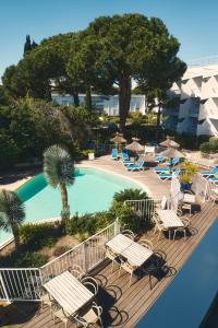 拉格朗德默特克扎尔酒店的一个带椅子的阳台和一个游泳池
