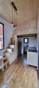 热拉梅Camping Les Granges Bas - Mobilhomes - Tiny House的一间铺有木地板的厨房和楼梯