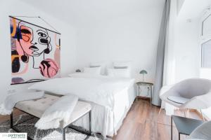 明斯特Aasee Apartment in top Lage 80m² mit 2 Schlafzimmern的卧室配有白色的床和墙上的绘画作品