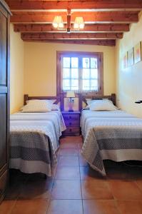 陶尔Apartamento con encanto的一间卧室设有两张床和窗户。
