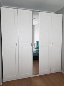 波兹南Apartament Wyłom 8的卧室配有白色橱柜和1张床。