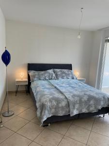洛迦诺Appartamento 464 nel CUORE di Locarno con piscina的一间卧室配有一张带蓝色棉被的床