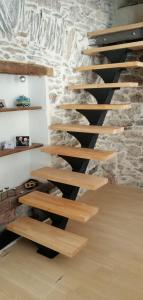 Les IlhesLa Maison du Voyageur的木楼梯,位于石墙的房间里