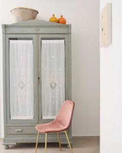 福贾B&B La Casa Pugliese的绿色橱柜旁的粉红色椅子