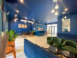富国Sel de Mer Apartment Grand World Phu Quoc的大堂设有蓝色的墙壁和绿色的桌椅