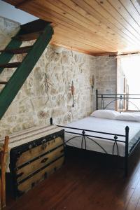 KalamotiYi artistry 1-bedroom medieval holiday house的一间卧室设有一张床和石墙