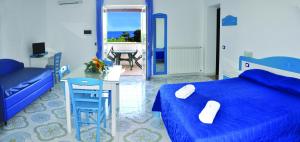 伊斯基亚Villa Myremi的蓝色卧室配有床、桌子和椅子