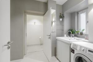 慕尼黑Exklusiv: Historisches Apartment mit Deckengewölbe的白色的浴室设有水槽和洗衣机。