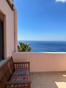 SellíaSeaview Villa Liandroy的一张长凳,坐在阳台上,眺望着大海