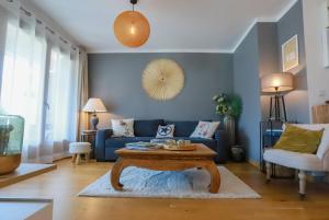 安锡Manoir 4 étoiles - 2 chambres, proche lac的客厅配有蓝色的沙发和桌子