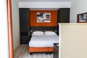 利多迪耶索罗维也纳酒店的一间卧室配有一张带橙色和黑色床头板的床