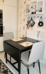 格洛米茨Küstenbude Nachtigall的厨房里一张黑桌子和两把椅子