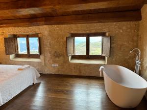 波波利Charme in Perillis的一间带浴缸、床和窗户的卧室