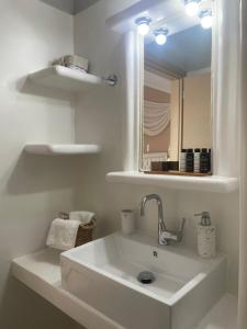阿达玛斯阿格罗斯一室公寓的白色的浴室设有水槽和镜子