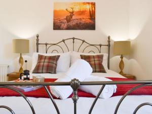 WinsfordKarslake Cottage的卧室配有一张挂着鹿画的床。
