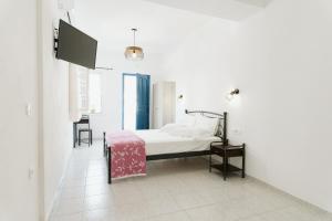 佩里萨Villa Limnes的一间白色客房内的床铺卧室