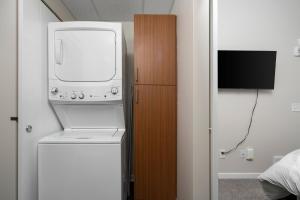 特拉弗斯城Sweet Tart Spot - Cozy TC Condo - Pet Friendly的电视室里的洗衣机和烘干机
