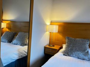 斯基普顿赫利厄特酒店的一间卧室配有两张床和镜子