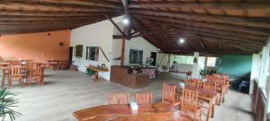 多明戈斯马丁斯Sítio e Pousada Vista Verde的一间带木桌椅的餐厅和一间房间
