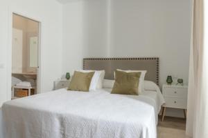 贝纳卢普-卡萨斯维耶哈斯Villa Girasol的白色卧室配有一张大白色床和两个枕头