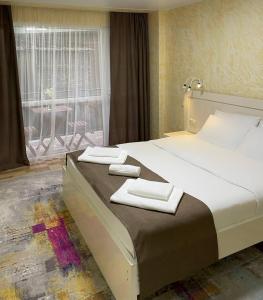 巴统Hotel Sonata的一间卧室配有一张大床和两条毛巾