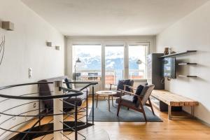 贝阿滕贝格Apartment Alpenrose 2.5 mit Mitbenutzung SPA & Wellness - GRIWA RENT AG的客厅配有桌椅和电视。