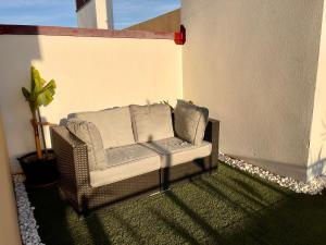 EsteponaParque Botanico Resort & Country Club的露台上配有带枕头的藤椅