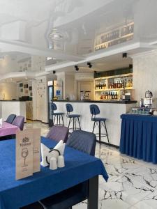 巴统Hotel Sonata的一间设有蓝色桌椅的餐厅和一间酒吧